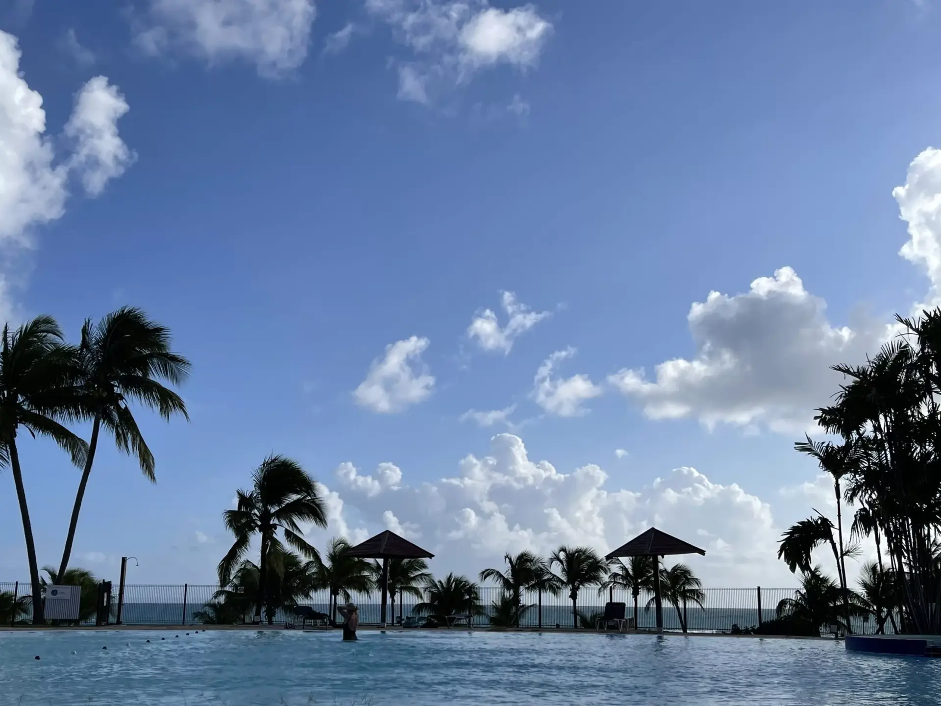 Vue du balcon du Bâtiment Barbadine Piscine et ciel tropical guadeloupéen